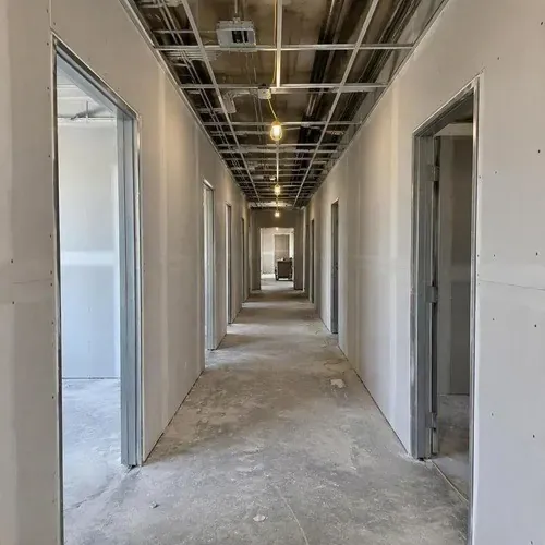 Commercial corridor drywall with ceiling grid above on a commercial drywall project in Kingston, ON