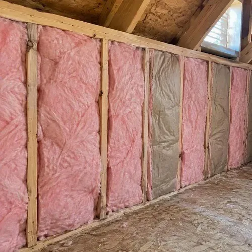 Fibreglass insulation batts in attic wall cavity during insulation and drywall work in Kingston, ON
