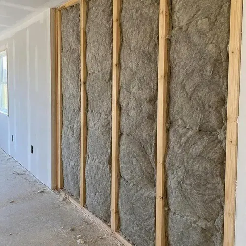 Acoustic insulation packed between wall studs on a drywall soundproofing job in Kingston, ON