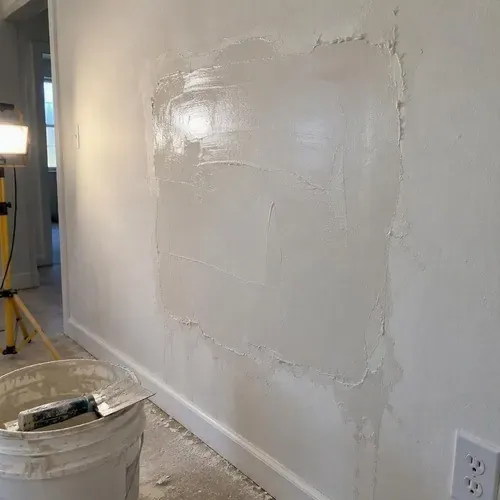 Skim coat applied over repaired plaster section during lath and plaster repair in a Kingston home