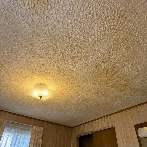 Dated yellowed popcorn textured bedroom ceiling during popcorn ceiling removal in Kingston, ON